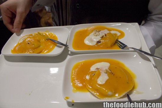 Ravioli filled with potato, cheddar, and proscuito di San Daniele with pumpkin sauce and a dash of bechamel